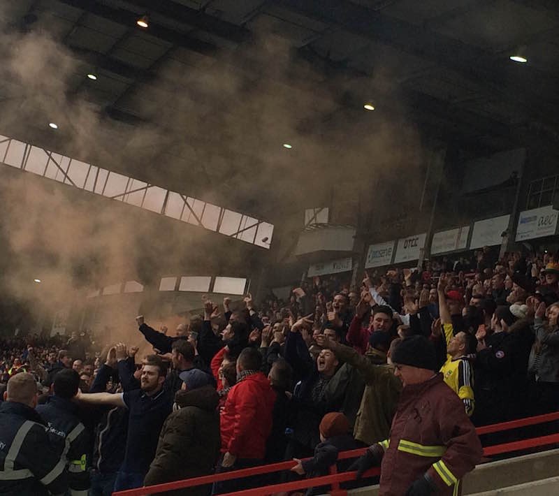 Fans celebrate Wrexham's first of three goals - orange smoke appears in the process...